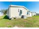 Home exterior with light-colored siding, awning-covered windows, and an air conditioning unit at 36838 Tara Ave, Zephyrhills, FL 33542