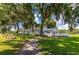 Charming recreational building nestled among mature trees with picnic tables and deck at 36838 Tara Ave, Zephyrhills, FL 33542