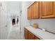 Functional hallway with wooden cabinets, white countertops, and access to multiple rooms at 36838 Tara Ave, Zephyrhills, FL 33542