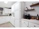 Kitchen features white cabinetry, stainless steel appliances, and floating shelves for an efficient use of space at 36838 Tara Ave, Zephyrhills, FL 33542