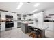 Bright kitchen featuring white cabinets, stainless steel appliances, a center island, and stylish countertops at 36838 Tara Ave, Zephyrhills, FL 33542