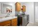 Bright laundry room with modern washer, dryer, sink, and wooden cabinets offering ample storage at 36838 Tara Ave, Zephyrhills, FL 33542