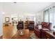 A living room featuring three red leather chairs, a table, an area rug, and wood flooring at 36838 Tara Ave, Zephyrhills, FL 33542