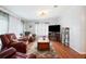 Comfortable living room with leather seating, a wooden coffee table, and large windows for natural light at 36838 Tara Ave, Zephyrhills, FL 33542