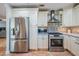 Modern kitchen with stainless steel appliances, cream cabinets, and complementing backsplash at 4383 Biscayne Dr, Hernando Beach, FL 34607