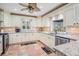 Bright kitchen features cream cabinets, granite countertops, stainless appliances, and a ceiling fan at 4383 Biscayne Dr, Hernando Beach, FL 34607