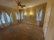 Bright bedroom features a ceiling fan, carpet, and multiple windows with curtains at 4425 Merrick Run Ln, Valrico, FL 33596