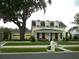 Charming two-story home featuring a welcoming front porch, mature trees, and well-manicured lawn at 4425 Merrick Run Ln, Valrico, FL 33596