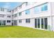 Backyard of condo building with sliding glass doors, lush greenery, and a well-maintained lawn at 4715 Bay Ne St # 126, St Petersburg, FL 33703