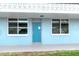 Close-up of unit 126, featuring a light-blue door between two windows with white trim at 4715 Bay Ne St # 126, St Petersburg, FL 33703