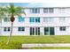 White condo building with impact windows and sliding glass doors, complemented by lush greenery and trees at 4715 Bay Ne St # 126, St Petersburg, FL 33703