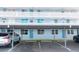 Bright blue condo building featuring covered parking, a second-story balcony, and neatly maintained landscaping at 4715 Bay Ne St # 126, St Petersburg, FL 33703