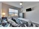 Stylish bedroom with ceiling fan, large windows, modern decor, and stylish nautical bedding at 5318 Wishing Arch Dr, Apollo Beach, FL 33572
