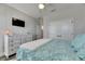 Serene bedroom features white walls, wood-look flooring, and a wall-mounted TV at 5318 Wishing Arch Dr, Apollo Beach, FL 33572
