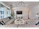 Bright living room featuring a large gray sofa, entertainment center, and access to the outdoors at 5318 Wishing Arch Dr, Apollo Beach, FL 33572