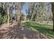 Large grassy backyard with a fire pit and deck under mossy trees at 5704 Half Moon Lake Rd, Tampa, FL 33625