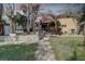 Landscaped backyard with a retaining wall and paver walkway leading to a covered patio, storage, and a serene environment at 5704 Half Moon Lake Rd, Tampa, FL 33625