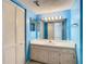 Bright bathroom with blue walls, ample lighting, and a spacious vanity at 6323 Newtown Cir # 23A1, Tampa, FL 33615