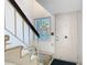 Bright entrance area with a white front door, staircase, and a window bringing in natural light at 6323 Newtown Cir # 23A1, Tampa, FL 33615