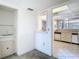 View of the kitchen with white cabinets and appliances, and a view to another room at 6323 Newtown Cir # 23A1, Tampa, FL 33615