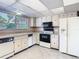 View of the kitchen featuring white appliances, tile floors, and plenty of natural light at 6323 Newtown Cir # 23A1, Tampa, FL 33615