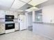 Kitchen features white appliances, tile floors, ample counter space, and view to adjacent room at 6323 Newtown Cir # 23A1, Tampa, FL 33615