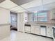 Bright kitchen with white cabinets, tile floors, and appliances, and a view to entry way at 6323 Newtown Cir # 23A1, Tampa, FL 33615