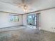 Spacious living room with ceiling fan, large window and glass doors leading out to the screened patio at 6323 Newtown Cir # 23A1, Tampa, FL 33615