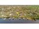Aerial view shows the property with the lake, boat dock and lush landscape at 680 George S St, Tarpon Springs, FL 34688