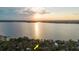 Aerial sunset view over the lake with home highlighted in yellow arrow at 680 George S St, Tarpon Springs, FL 34688