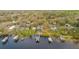 Real estate aerial view of a lakefront home with multiple docks for boats on a sunny day at 680 George S St, Tarpon Springs, FL 34688