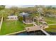 Aerial view of backyard featuring home with enclosed screened porch, a wooden dock, and lake access at 680 George S St, Tarpon Springs, FL 34688