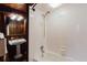 Cozy bathroom features wood paneling, pedestal sink, tub, and a tiled shower in neutral tones at 680 George S St, Tarpon Springs, FL 34688