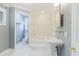Bright bathroom featuring a pedestal sink, shower/tub combo, and tiled walls at 680 George S St, Tarpon Springs, FL 34688