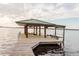 Waterfront dock featuring a covered boat lift and a boat launch with stunning views of the lake at 680 George S St, Tarpon Springs, FL 34688