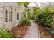 Landscaped front yard with a brick pathway and lush tropical foliage and unique exterior features at 680 George S St, Tarpon Springs, FL 34688