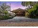 Stone façade garage featuring a stylish wooden carport with detailed landscaping at 680 George S St, Tarpon Springs, FL 34688