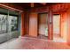 Hallway featuring brick floors, wood paneling, leading to screened-in patio and bathroom at 680 George S St, Tarpon Springs, FL 34688