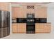 This kitchen boasts wood cabinets, stainless appliances, and black countertops at 680 George S St, Tarpon Springs, FL 34688
