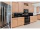 This kitchen has wood cabinets, stainless appliances, and black countertops at 680 George S St, Tarpon Springs, FL 34688
