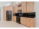 This kitchen has wood cabinets, stainless appliances, and black countertops at 680 George S St, Tarpon Springs, FL 34688