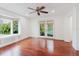 Bright living room with a large bay window, hardwood floors, ceiling fan, and french doors at 680 George S St, Tarpon Springs, FL 34688