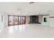 Spacious living room featuring tile floors, a stone fireplace, and wooden doors leading to an outdoor area at 680 George S St, Tarpon Springs, FL 34688
