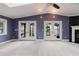 Living room with vaulted ceiling, French doors to the porch, and a fireplace, providing natural light at 680 George S St, Tarpon Springs, FL 34688