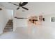 Open floor plan featuring tile floors, a staircase, and kitchen, providing a seamless living experience at 680 George S St, Tarpon Springs, FL 34688