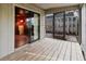 View of covered patio with wood floor planks and view of the fenced backyard, and additional sunroom at 680 George S St, Tarpon Springs, FL 34688