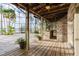 Expansive screened patio with a built-in stone bar, wooden deck, and views of the waterfront at 680 George S St, Tarpon Springs, FL 34688