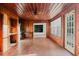 Bright sunroom featuring wood paneling, brick floors, a ceiling fan, and multiple windows at 680 George S St, Tarpon Springs, FL 34688