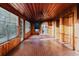 Spacious sunroom with wood paneling, brick floors, natural light, and a ceiling fan at 680 George S St, Tarpon Springs, FL 34688