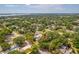 A lush, green neighborhood is seen from above, dotted with trees and glimpses of a lake in the distance at 7125 6Th N Ave, St Petersburg, FL 33710